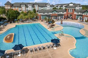 Waldorf apartment for rent - A large swimming pool with a diving board and sun loungers.