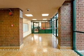 Bronx apartment for rent - A long hallway with brick walls and tile flooring.