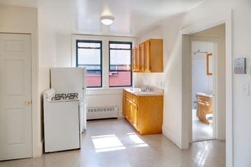 Hempstead apartment for rent - A kitchen with white appliances and wooden cabinets.