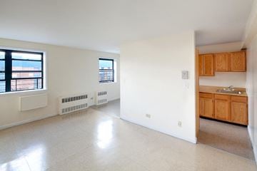 Brooklyn apartment for rent - A spacious living room with a kitchenette and a window.