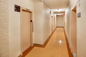 Brooklyn apartment for rent - A long hallway with doors on either side and an exit sign at the end.