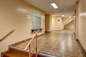 Bronx apartment for rent - A hallway with a staircase and a calendar on the wall.