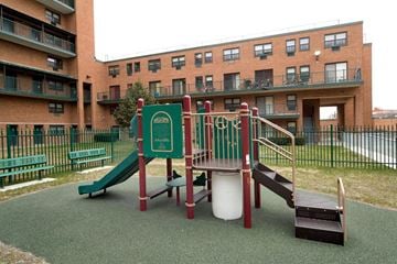 Jamaica apartment for rent - A playground with a green slide and a red and white slide.