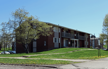 Canton apartment for rent - A red brick apartment building with a tree in front.