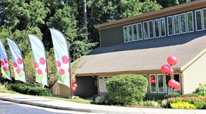 Clarkston apartment for rent - A house with a green lawn and a flag with red dots at Clarkston Station Apartments, Clarkston, 30021