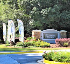 Clarkston apartment for rent - The entrance to Woodside Village is marked by a large sign and several flags at Woodside Village Apartments, Clarkston