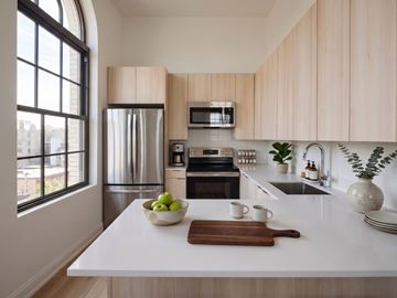 Jersey City apartment for rent - A kitchen with a white countertop and wooden cabinets.