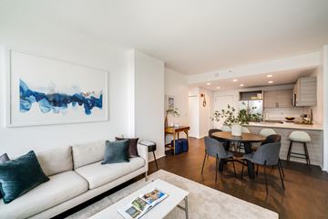 Fort Lee apartment for rent - A living room with a white couch and a painting on the wall.
