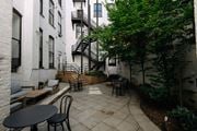 Hoboken apartment for rent - A patio with a table and chairs is surrounded by buildings.