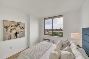 Edgewater apartment for rent - A bedroom with a large bed and a painting on the wall.