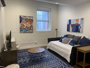 New Haven apartment for rent - A bedroom with a bed, a chair, a table, a TV, and two paintings on the wall.