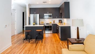 Milford apartment for rent - A modern kitchen with dark wood cabinets and a white fridge.