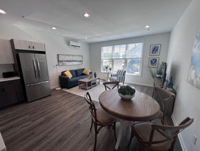 Milford apartment for rent - A kitchen with a refrigerator, a dining table with chairs, and a couch with pillows.