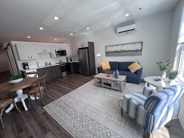 Milford apartment for rent - A living room with a blue couch and a wooden coffee table.
