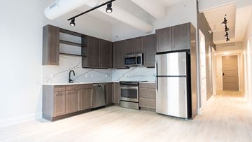 Detroit apartment for rent - a large kitchen with stainless steel appliances and wooden cabinets