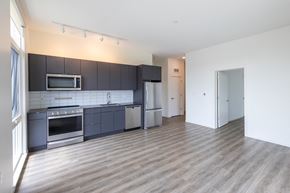 Detroit apartment for rent - an empty room with a kitchen and a door to a hallway
