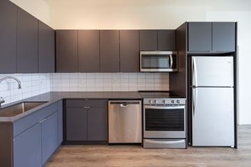 Detroit apartment for rent - A modern kitchen with dark brown cabinets and stainless steel appliances.