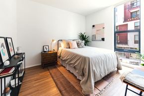 Detroit apartment for rent - a bedroom with a bed and a large window