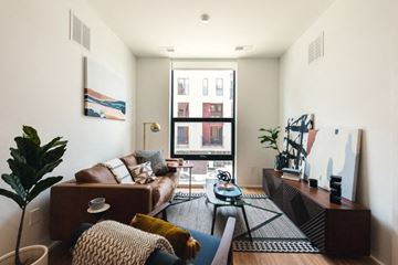 Detroit apartment for rent - A living room with a brown couch and a coffee table.