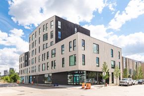 Detroit apartment for rent - a view of the building from the street with cars parked in front of it