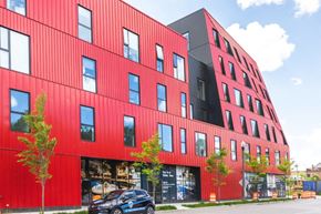 Detroit apartment for rent - a red building with a black car parked in front of it