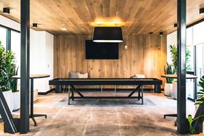 Detroit apartment for rent - A conference room with a long table and a flat screen TV mounted on the wall.