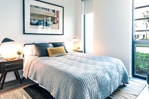 Detroit apartment for rent - A bedroom with a large bed and a framed picture on the wall.