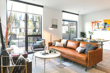 Detroit apartment for rent - A living room with a brown leather couch and a white coffee table.