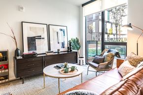 Detroit apartment for rent - a living room with a brown leather couch and a large window