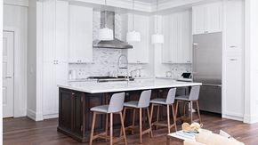 Detroit apartment for rent - Dining area and chairs with white cabinetry, hanging light fixtures, and stainless steel appliances.