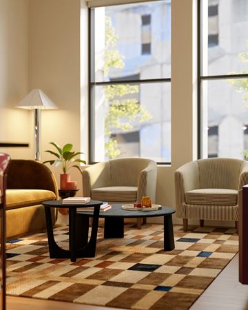 Detroit apartment for rent - A living room with a brown and white checkered rug and a yellow chair.