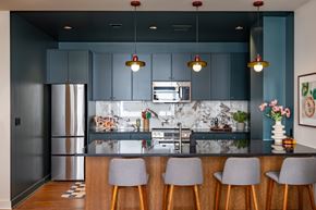 Detroit apartment for rent - A kitchen at The Belle with dark blue cabinets and a marble backsplash.