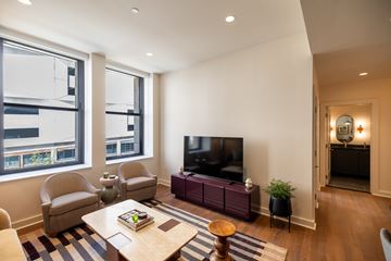 Detroit apartment for rent - A living room with a television, chairs, and a coffee table.