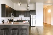 Detroit apartment for rent - a kitchen with black cabinets and stainless steel appliances at The Ferguson Apartments, Detroit, Michigan