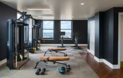 Detroit apartment for rent - The Stott fitness center with a variety of equipment including a squat rack, bench, and weights.