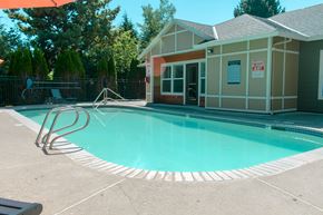 Tigard apartment for rent - A pool with a building next to it.