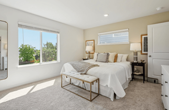 Bright bedroom with large windows and neutral tones