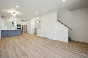 Open concept living space with kitchen and staircase