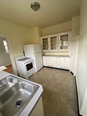 Portland apartment for rent - a kitchen with white cabinets and a stainless steel sink