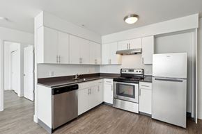 Portland apartment for rent - A modern kitchen with white cabinets and stainless steel appliances.