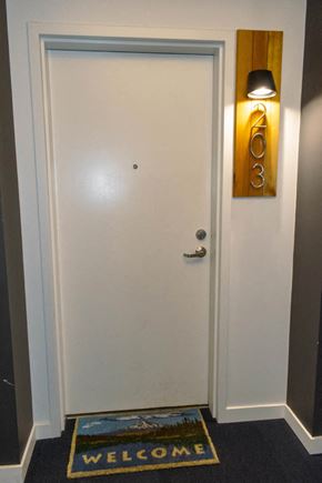 Portland apartment for rent - A white door with a gold number 203 on the wall above it.