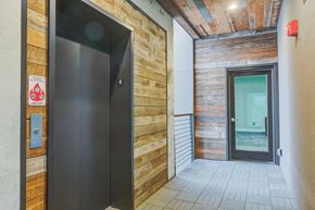 Portland apartment for rent - the entrance to a building with a black door and a wooden wall