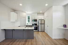 Oregon City townhouse for rent - Kitchen with stainless appliances and gray island at Holmes Park Townhomes Apartments, Oregon, 97045