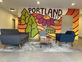 Portland apartment for rent - A room with a Portland mural on the wall and two chairs and a table in front of it.