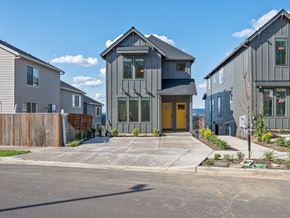 Tigard apartment for rent - A modern house with a yellow door is surrounded by other houses.