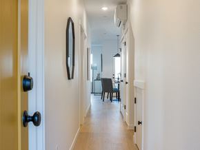 Tigard apartment for rent - A hallway with a black door and a mirror on the wall.