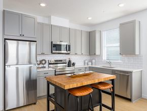 Tigard apartment for rent - A modern kitchen with a wooden island and stainless steel appliances.
