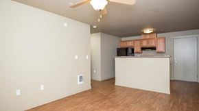 Portland apartment for rent - an empty living room with a kitchen and a ceiling fan