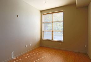 Portland apartment for rent - a bedroom with a large window and wooden floors