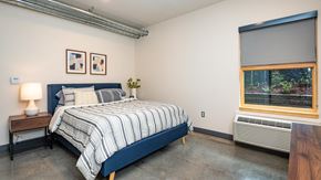 Portland apartment for rent - A bedroom with a bed, nightstand, and window.